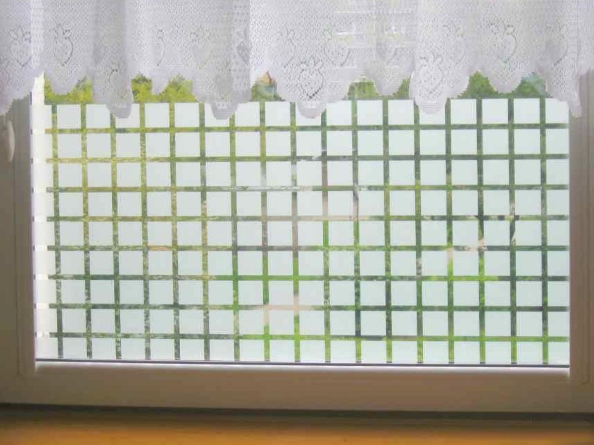 Dekoracyjna folia okienna w kratkę na dolnej części okna jako alternatywa dla firanek w kuchni