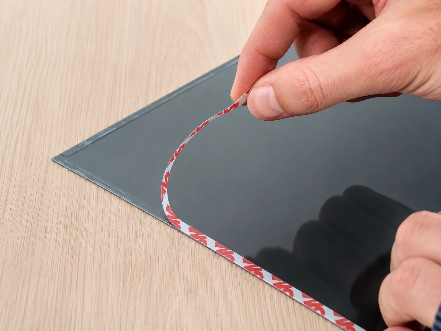 Removing the adhesive protection tape from a privacy filter