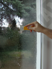 Cleaning window glass with a scraper before film installation